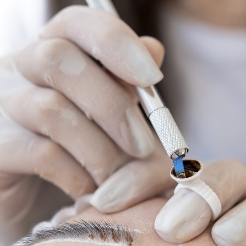 beautician-doing-microblading-treatment-client-s-eyebrows